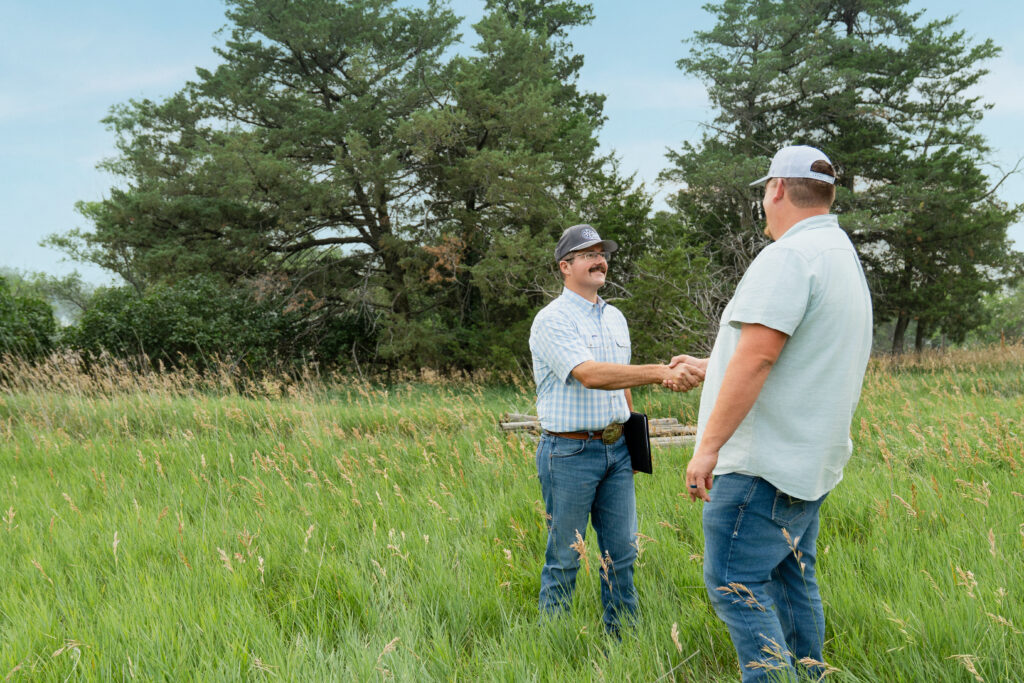 chase dodson shaking hands client landowner farm and ranch management photo by a moment photography amy minshull north platte ne